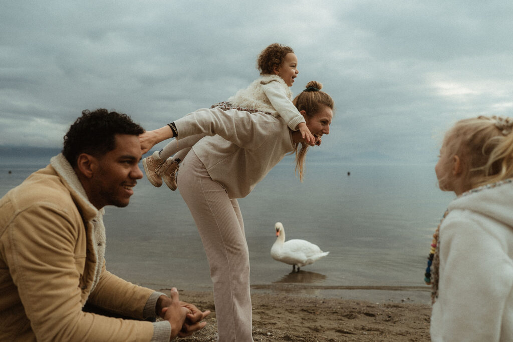 shooting photo en famille à vidy, deux parents et deux enfants jouent au bord du lac